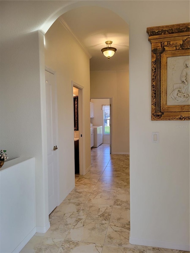 corridor with crown molding and independent washer and dryer