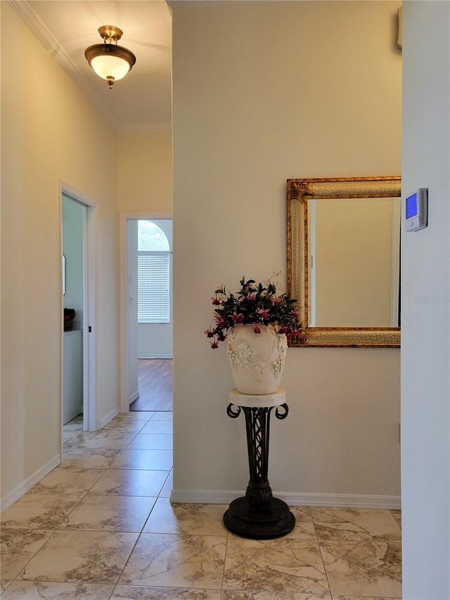 corridor with a high ceiling and crown molding