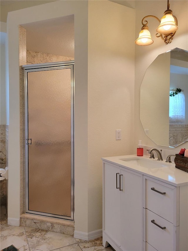 bathroom featuring a shower with shower door and vanity