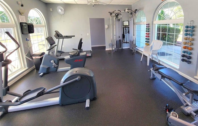 exercise room featuring a paneled ceiling and plenty of natural light