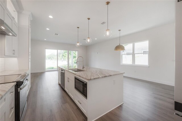 kitchen featuring a kitchen island with sink, dark wood-type flooring, hanging light fixtures, appliances with stainless steel finishes, and white cabinetry