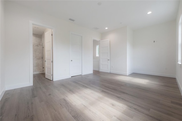 unfurnished bedroom featuring light hardwood / wood-style flooring and ensuite bath