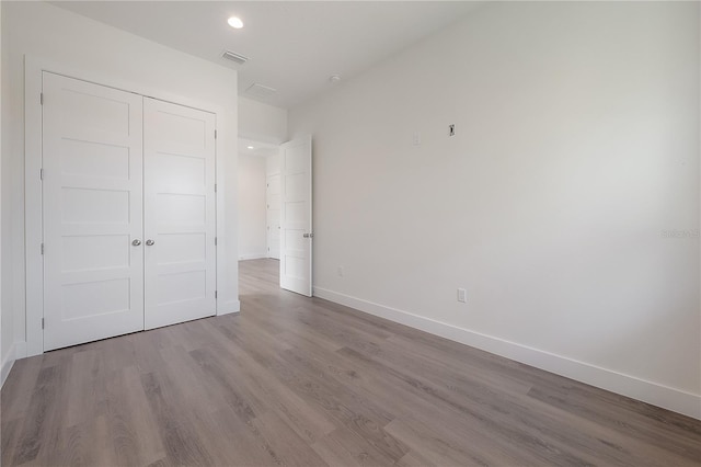 unfurnished bedroom with a closet and light hardwood / wood-style flooring