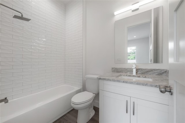 full bathroom featuring tiled shower / bath combo, hardwood / wood-style flooring, vanity, and toilet