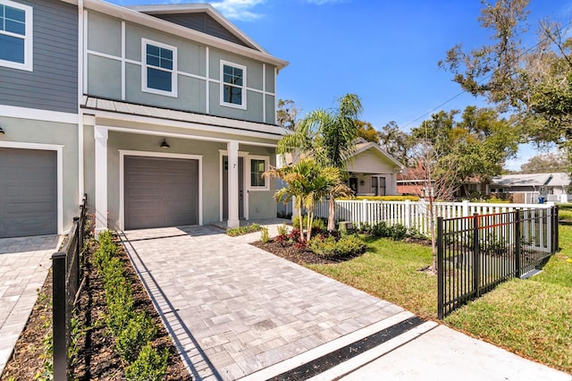 view of front of house with fence, a porch, stucco siding, a garage, and decorative driveway