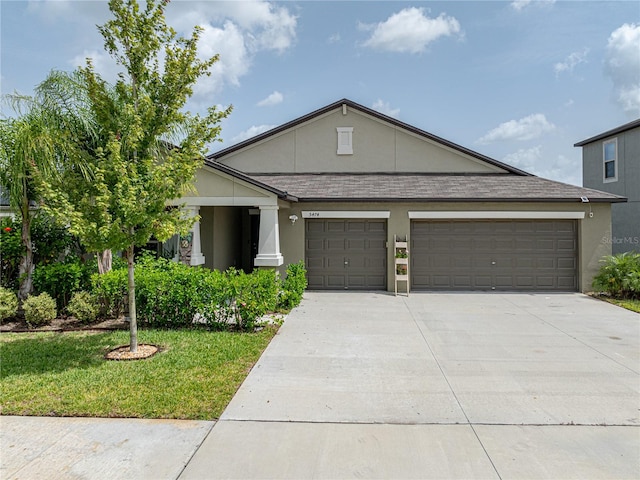 view of front of home with a garage and a front lawn