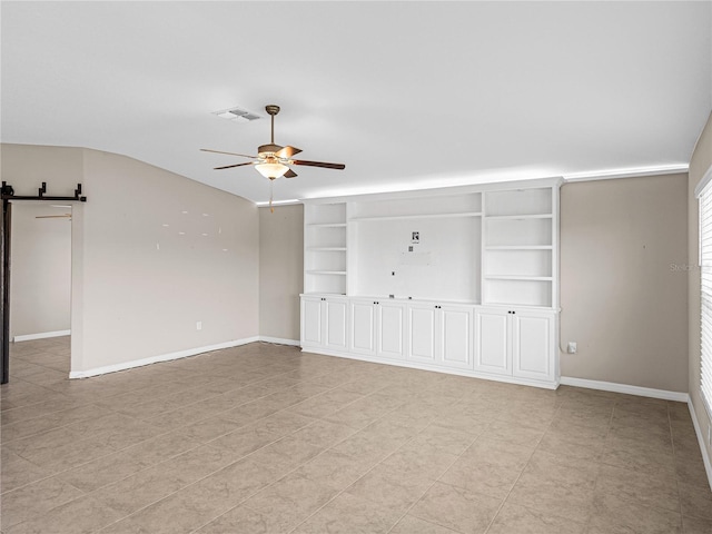 unfurnished room featuring vaulted ceiling, a barn door, and ceiling fan