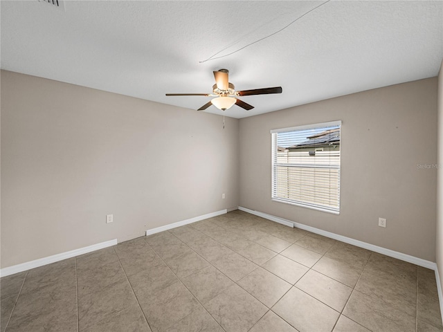 empty room featuring light tile patterned floors, a textured ceiling, and ceiling fan