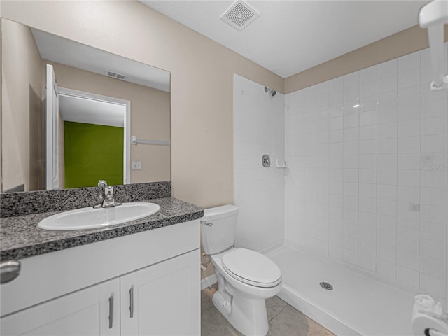 bathroom with vanity, tiled shower, tile patterned floors, and toilet