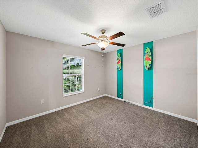 carpeted spare room featuring ceiling fan and a textured ceiling