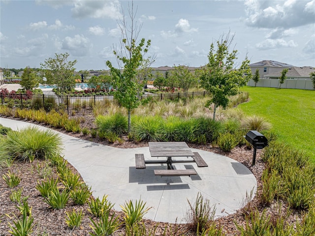 view of property's community featuring a yard and a patio area