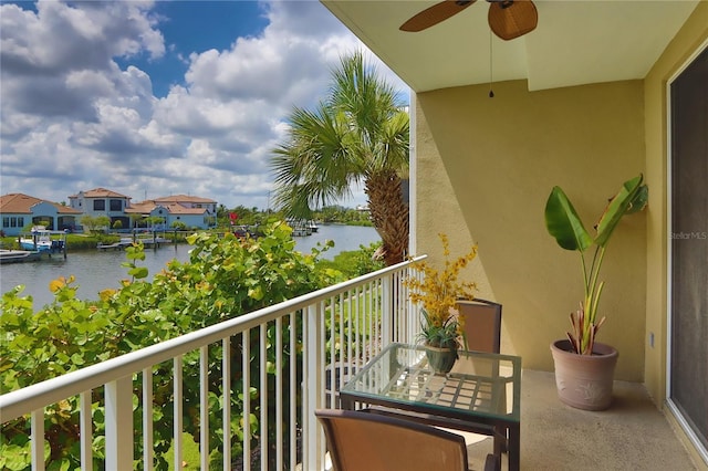 balcony with ceiling fan and a water view