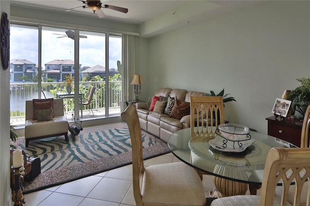 tiled living room featuring a water view and ceiling fan