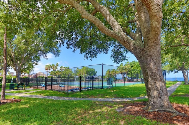 view of home's community with a lawn and tennis court
