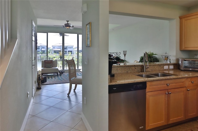 kitchen featuring light tile patterned flooring, sink, light stone counters, dishwasher, and ceiling fan