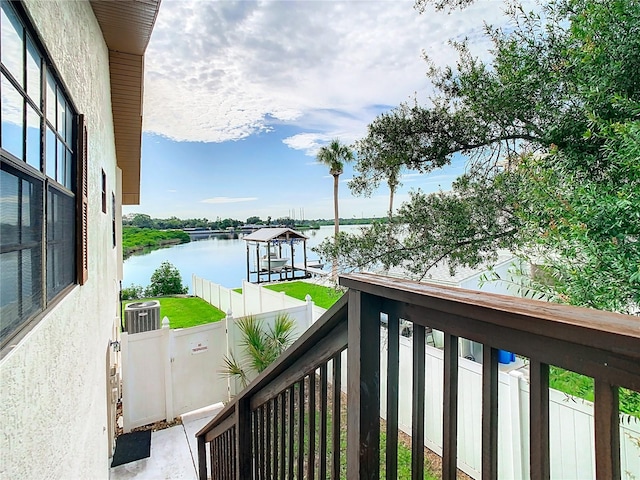 balcony featuring central air condition unit, a water view, and a boat dock