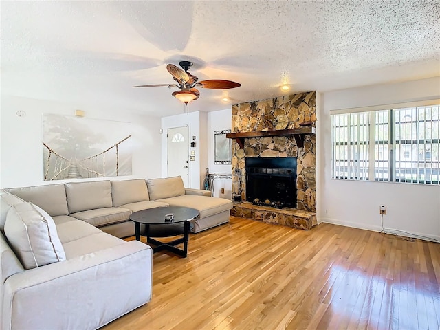 living room with light hardwood / wood-style flooring, a fireplace, and ceiling fan