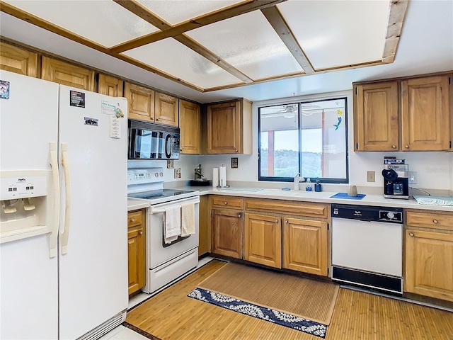 kitchen featuring sink, light hardwood / wood-style flooring, and white appliances