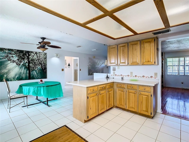 kitchen featuring kitchen peninsula, light tile patterned floors, and ceiling fan