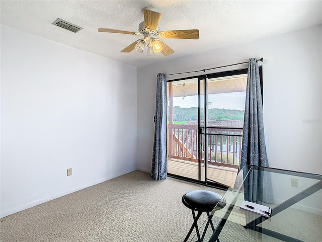 unfurnished office with a textured ceiling, carpet floors, and ceiling fan