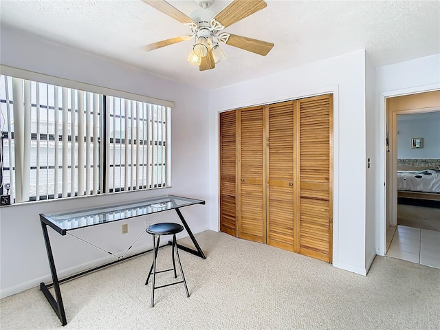 office area featuring carpet floors, a textured ceiling, and ceiling fan