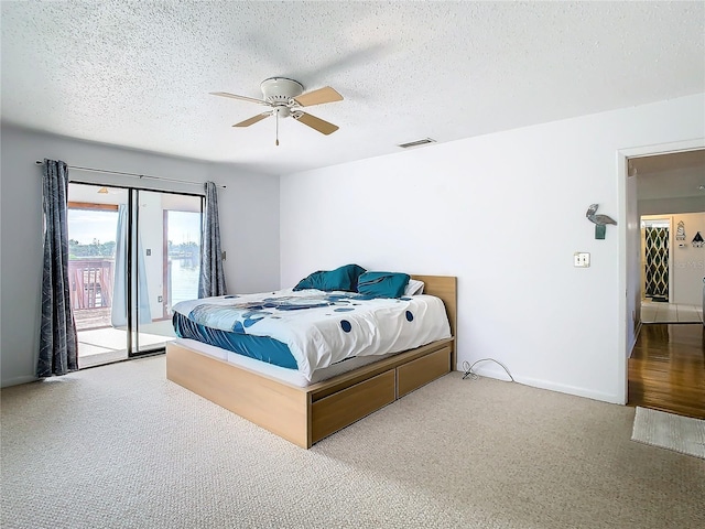 carpeted bedroom featuring a textured ceiling, ceiling fan, and access to exterior