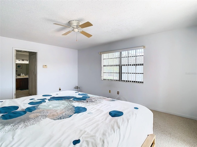 carpeted bedroom with ensuite bath, a textured ceiling, and ceiling fan