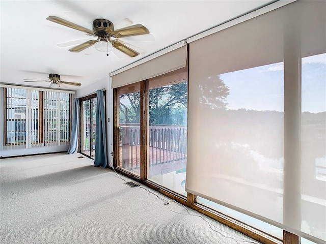 unfurnished sunroom featuring ceiling fan