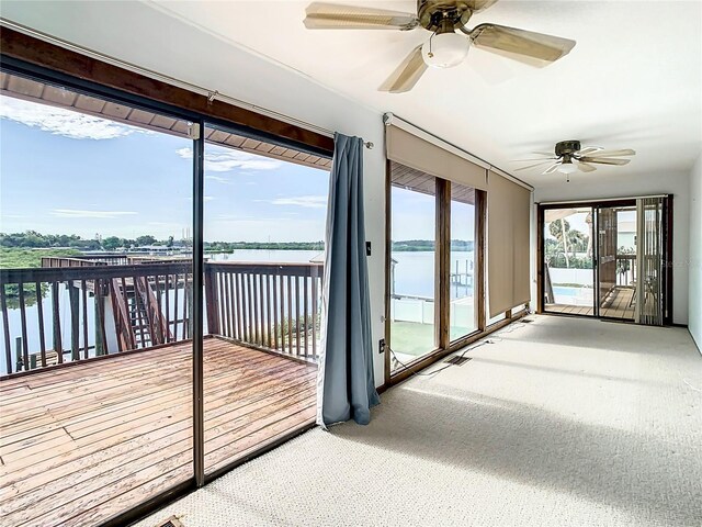 unfurnished sunroom featuring ceiling fan