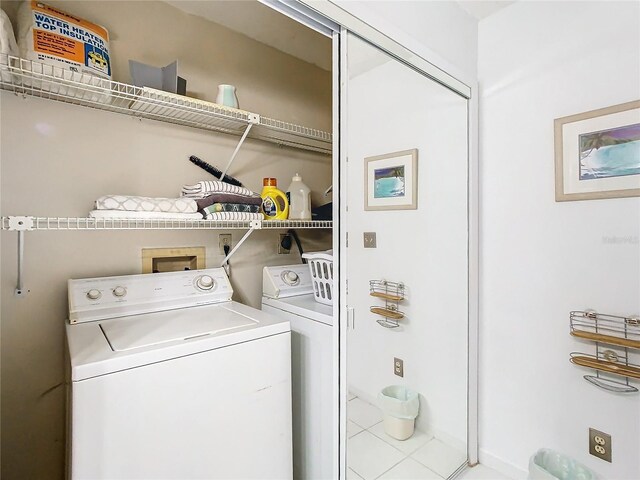 laundry room with washing machine and dryer and light tile patterned floors