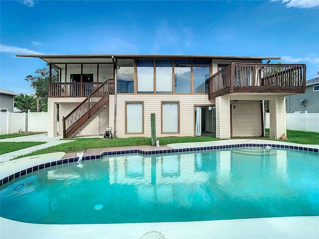 rear view of property with a balcony and a fenced in pool