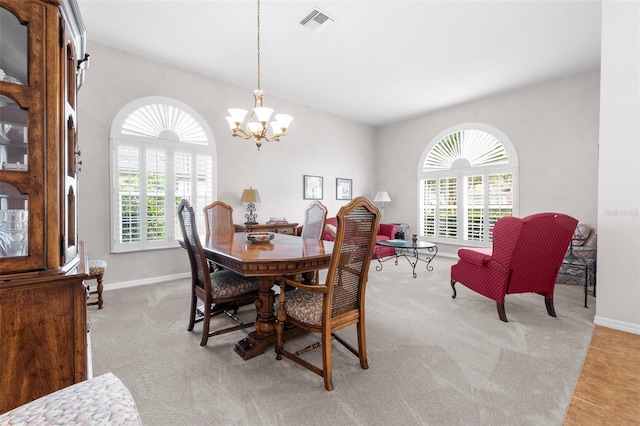 carpeted dining area featuring a notable chandelier