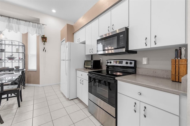 kitchen featuring light tile patterned floors, appliances with stainless steel finishes, and white cabinets