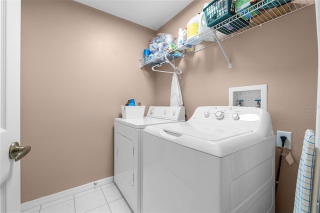 laundry room with light tile patterned floors and washer and clothes dryer