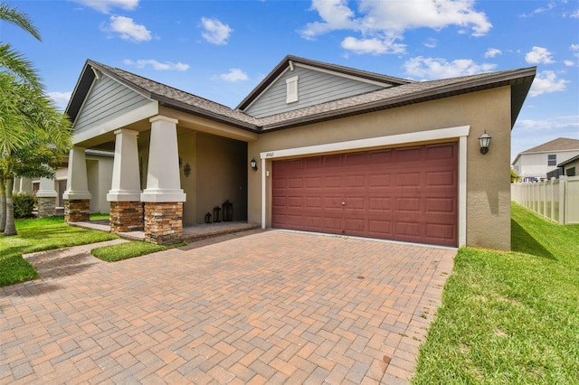 view of front facade with decorative driveway, a garage, a front lawn, and stucco siding