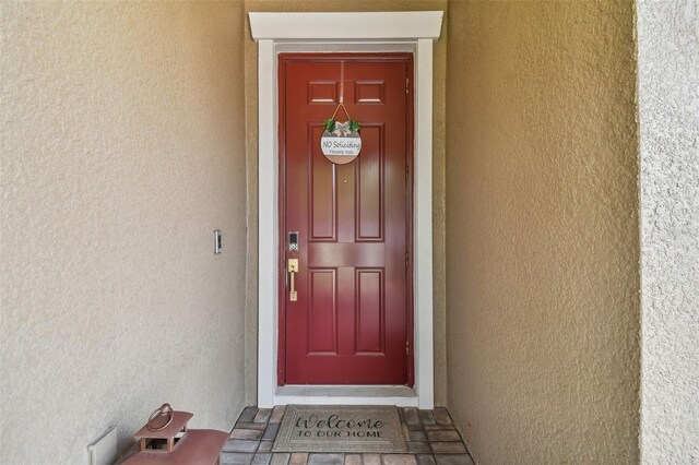 view of exterior entry with stucco siding