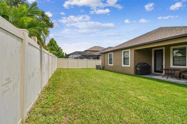 view of yard featuring a fenced backyard, a patio, and central air condition unit