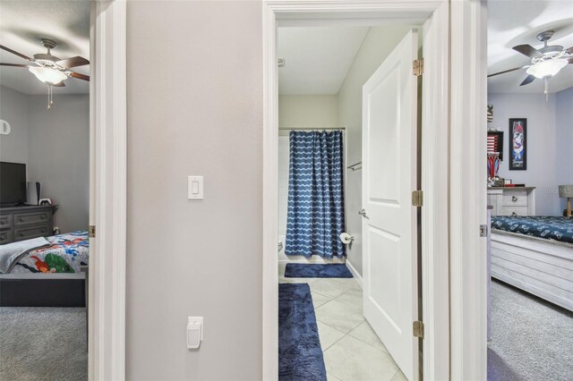 full bath with ensuite bathroom, tile patterned floors, ceiling fan, and curtained shower