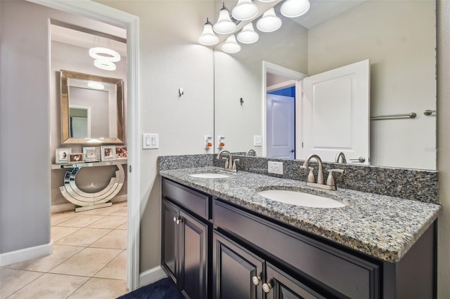 bathroom featuring a sink, baseboards, and tile patterned flooring