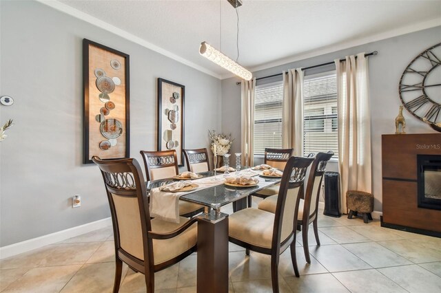 dining space with crown molding, baseboards, and light tile patterned flooring