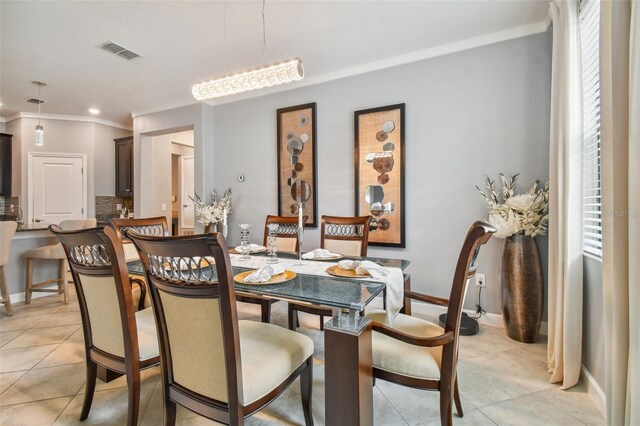 dining space featuring crown molding, light tile patterned floors, baseboards, and visible vents
