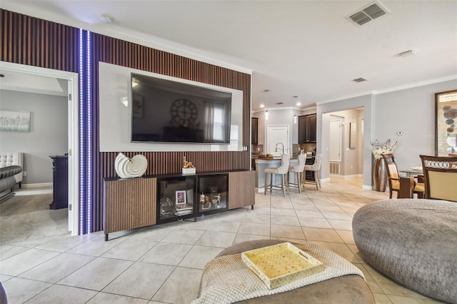 living area featuring crown molding, baseboards, visible vents, and light tile patterned floors