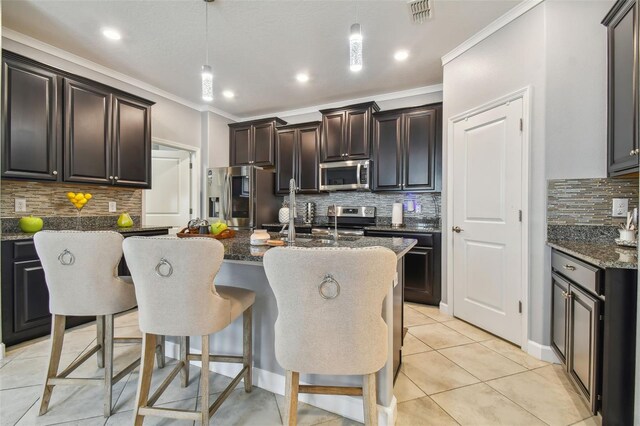 kitchen featuring decorative backsplash, ornamental molding, dark stone countertops, decorative light fixtures, and stainless steel appliances
