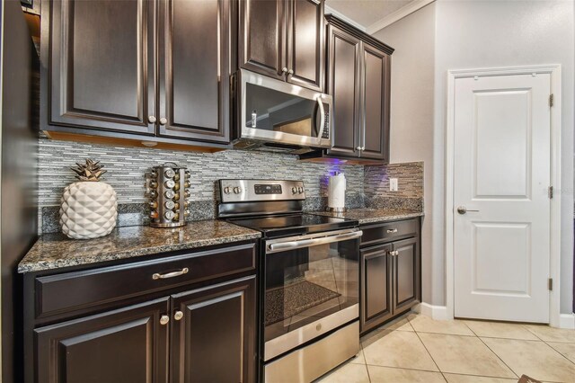 kitchen with ornamental molding, dark brown cabinets, light tile patterned floors, backsplash, and stainless steel appliances
