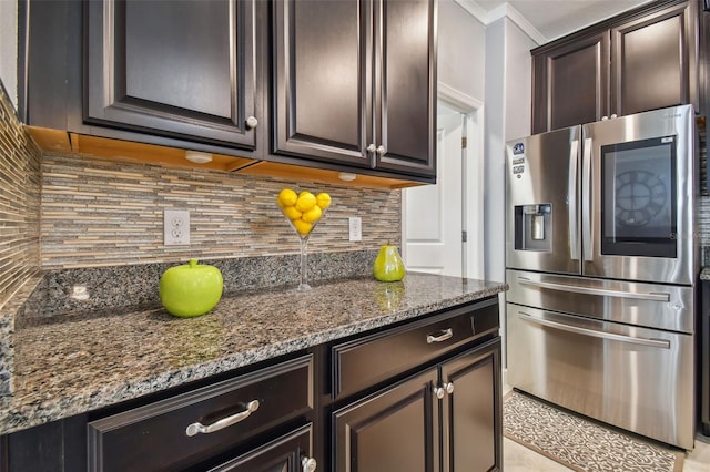 kitchen featuring stainless steel fridge with ice dispenser, backsplash, dark stone countertops, and dark brown cabinets