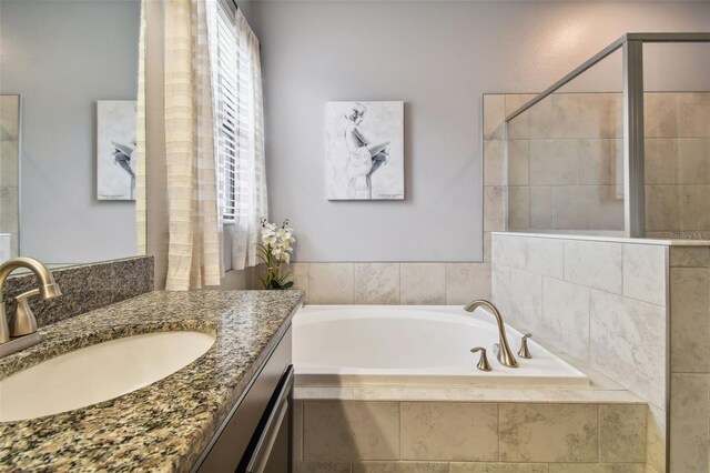 full bath with vanity, a stall shower, and a bath