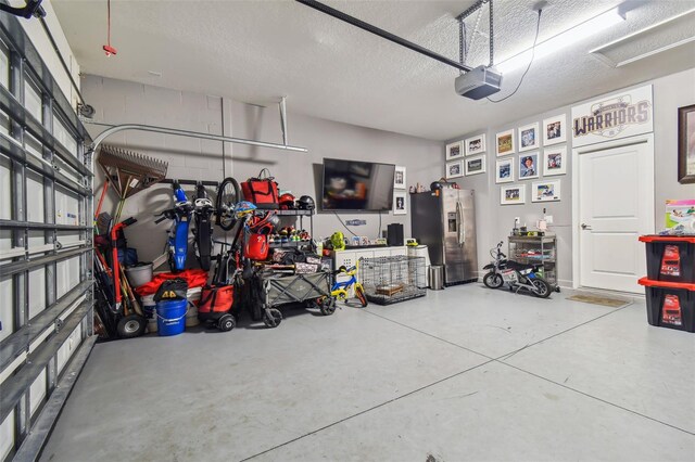garage with stainless steel fridge with ice dispenser and a garage door opener