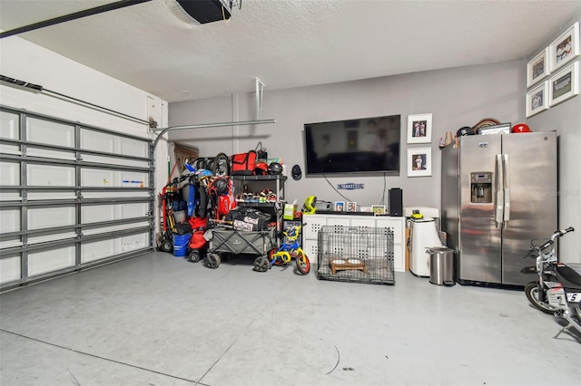 garage featuring stainless steel fridge and a garage door opener