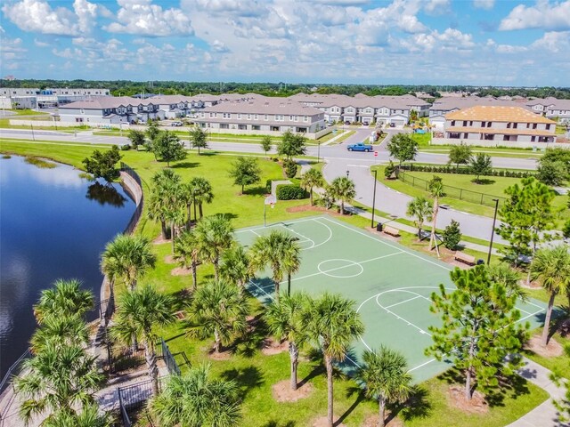 view of basketball court with a yard, a water view, community basketball court, and a residential view