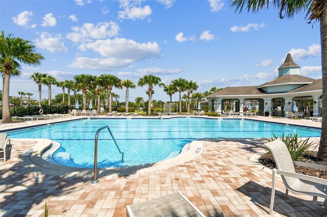 community pool featuring fence and a patio area